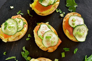 Toasted bread with salmon, scrambled eggs and cucumber