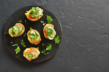Canape with salmon, scrambled eggs and cucumber