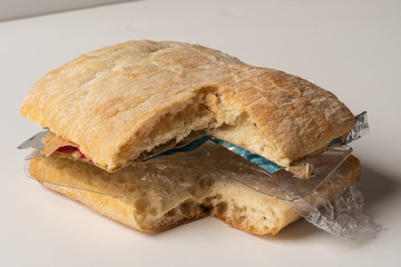 Fresh tasty cut out burger panini with plastic waste and paper cardboard inside on white background. Recycled waste in our food concept