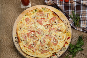 Pizza thin with sausage, mushrooms, cheese, spices, a glass of juice, tomatoes, nuts
