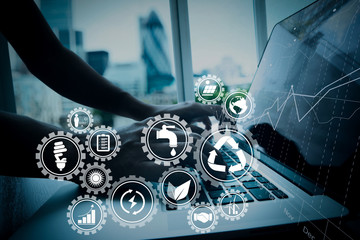 business man hand working on laptop computer with business graph information diagram on wooden desk as concept