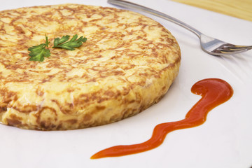 Spanish omelette with potatoes and onions with tomato sauce