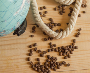 Happy day of conception Columbus. A globe, rope, coffee beans on wooden Board