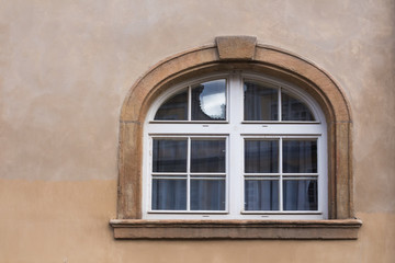 Fototapeta na wymiar Window with a stone frame and an arch in Prague, Czech republic