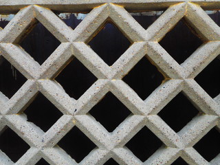 diamond pattern concrete lattice fence on black background