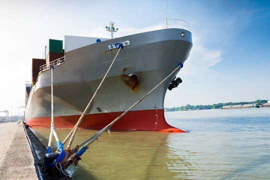 cargo container ship waithing for loading big tanker from ship to container yard port.