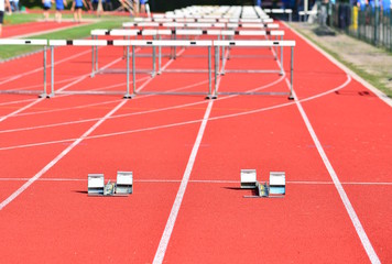 A hurdle race on red running in stadium track; success concept.