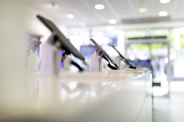 Close up of cell phones or mobile phones on display in a modern, clean and contemporary shop or mall