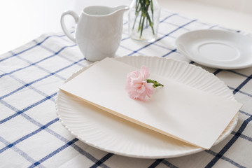 Fototapeta na wymiar Table setting with dishes, cutlery and flowers on white background
