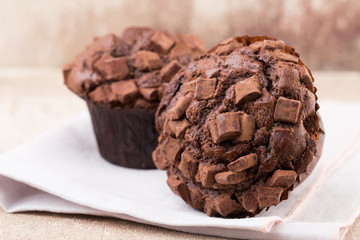 Homemade muffins with chocolate, vintage background.