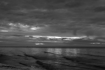  The sun began to rise from the sea in the morning backdrop black and white style.