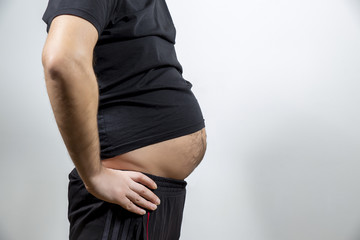 Adult man is showing his fat, unhealty belly