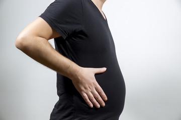 Adult man is showing his fat, unhealty belly