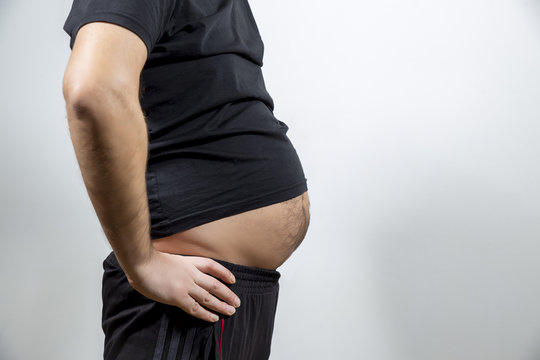 Adult man is showing his fat, unhealty belly