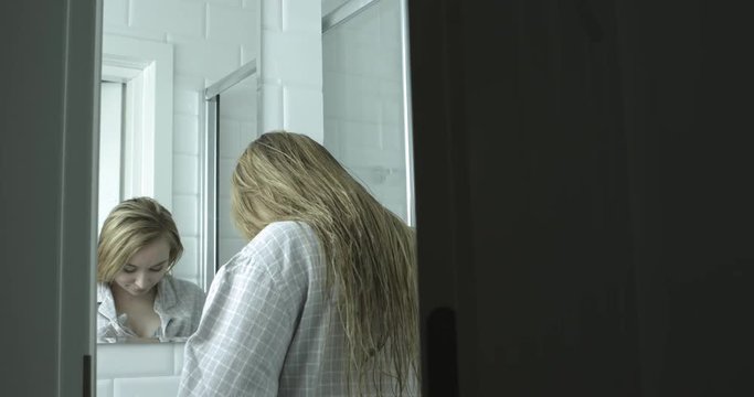 Portrait of beautiful shocked woman closing doors to bathroom.