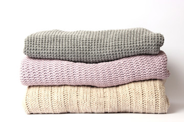 an ideal stack of warm clothes on a monophonic background. minimalism.