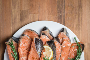fresh raw red fish fillet on white plate and rosemary