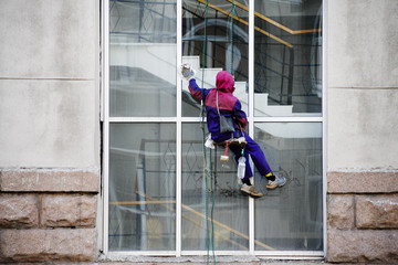Industrial climber washes the window