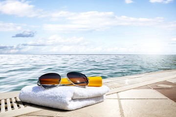 sunglasses and towel with sea landscape 