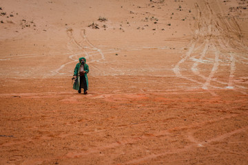 man in a chemical protection suit with arms in the desert. concept survivor after the war.