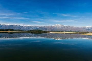 Obraz premium View over the lake with snowy mountains. Beautiful mountain landscape. Afternoon mountainous Spanish scenery 