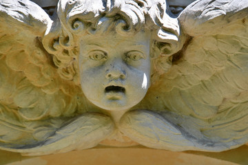 Weathered sculpture of an angel on top of a crypt. The old Berlin-Stahnsdorf cemetery 
