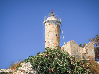Fototapeta na wymiar Old lighthouse on a rock in sunny day on the blue sky background