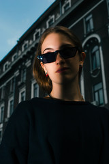 Stylish and fashionable girl with glasses on the city street