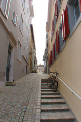 quiet side street in Zurich (Switzerland), bicycle on steps, blue windows with wooden red shutters