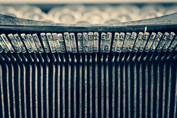 Dirty vintage typewriter keyboard focusing on the typebars