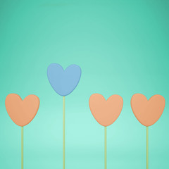 Minimal love and care concept idea, orange and blue heart shape candies on turquoise pastel background with copy space