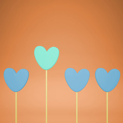 Minimal love and care concept idea, blue and turquoise heart shape candies on orange pastel background with copy space