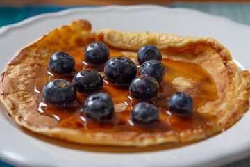 Homemade pancake with fresh blueberries smothered in maple syrup