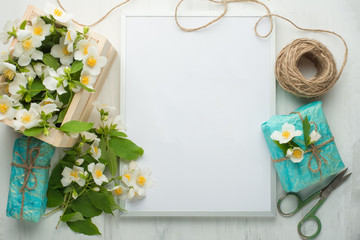 Empty frame with flowers and gifts on a light background. It is possible to use both for inscription, demonstration of fonts, and as a postcard