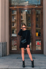 Stylish and fashionable girl with glasses on the city street