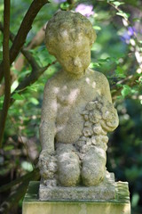 Weathered sculpture of an angel on a tomb.