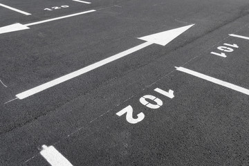 Fresh painted parking places, gray new asphalt, white arrows and numbers