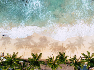 Blick von oben auf eine Frau, die sich beim Sonnenbaden auf dem tropischen Strand, Sommerurlaub, Drohnenschuss hinlegt
