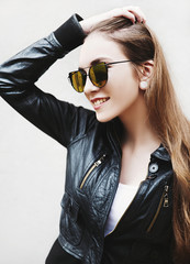 Young woman wearing sunglasses and leather jacket