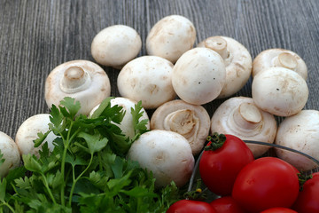 Tomato and parsley next to edible culture mushrooms
