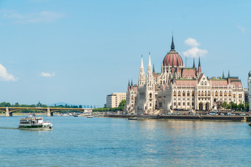 Fototapeta na wymiar Hungarian Parliament and travel boats sailing the Danube river in Budapest, Hungary.