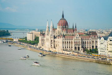 Fototapeta premium Parlament węgierski i łodzie turystyczne pływające po Dunaju w Budapeszcie na Węgrzech.
