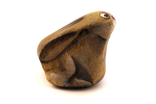A picture of a hare on a stone with acrylic paints, an image on a fir-tree background.