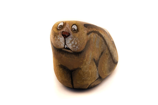 A frightened hare painted with paint on the surface of a stone, a white background.