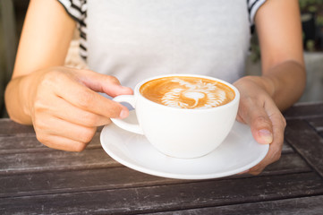 Woman drinking hot latte coffee.