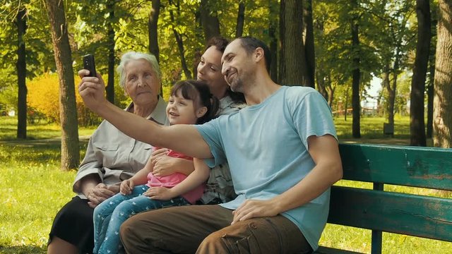 The family is photographed in the park. The family is photographed with the phone.