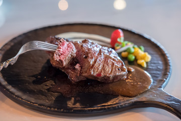 Medium rare meat on plate with sauce