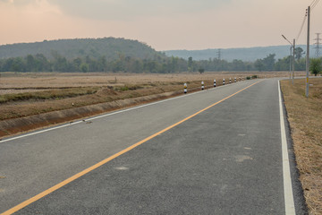 Fototapeta premium road up hill to the mountain top at at sunny sunset.