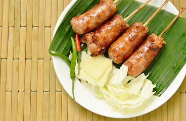 grilled Thai sausage stuffed rice and pork eat with fresh vegetable on plate