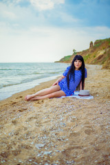  A girl in a striped dress and hat on the beach